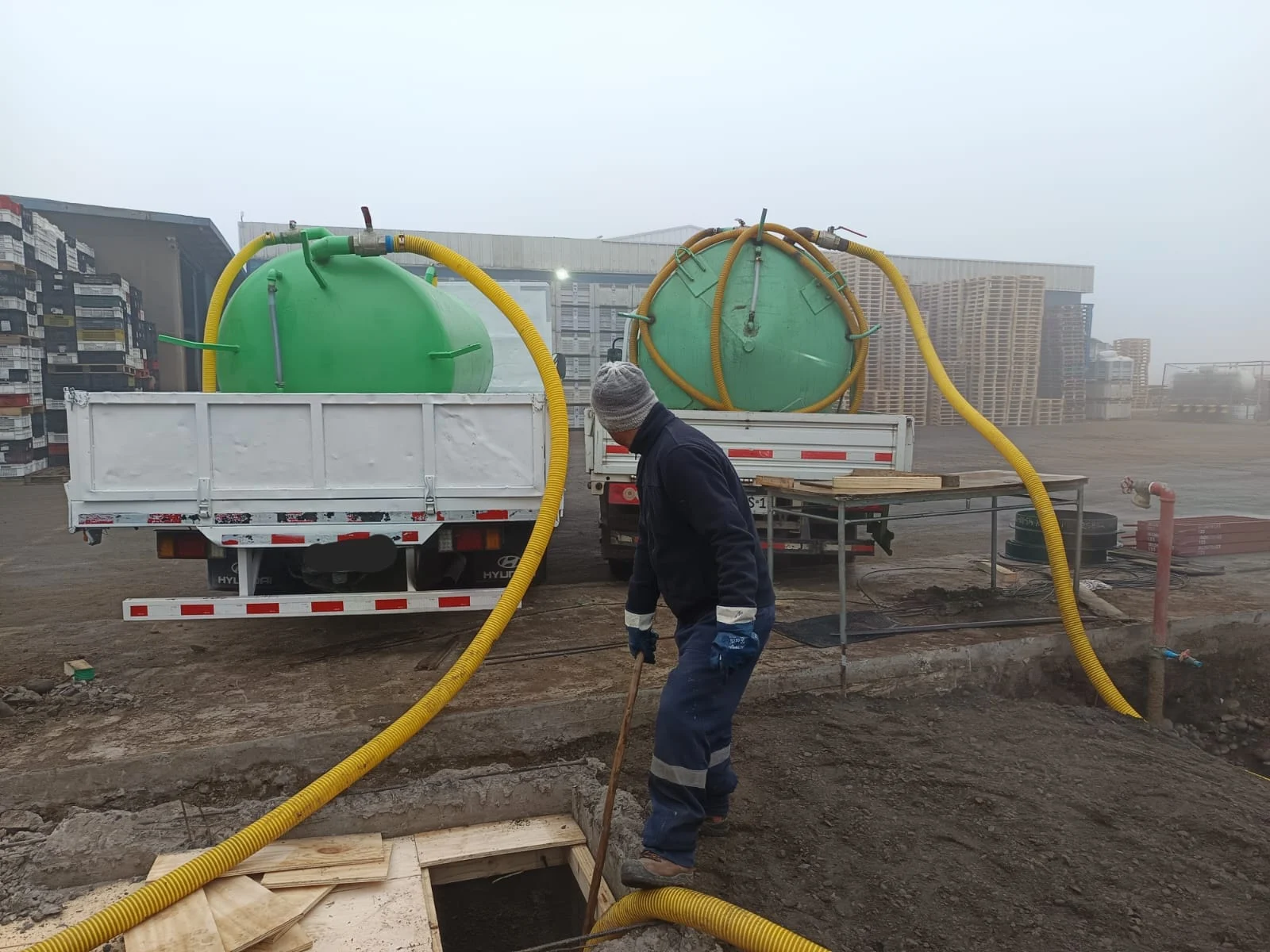 Trabajador de Servivalle operando una manguera junto al camión en una instalación industrial